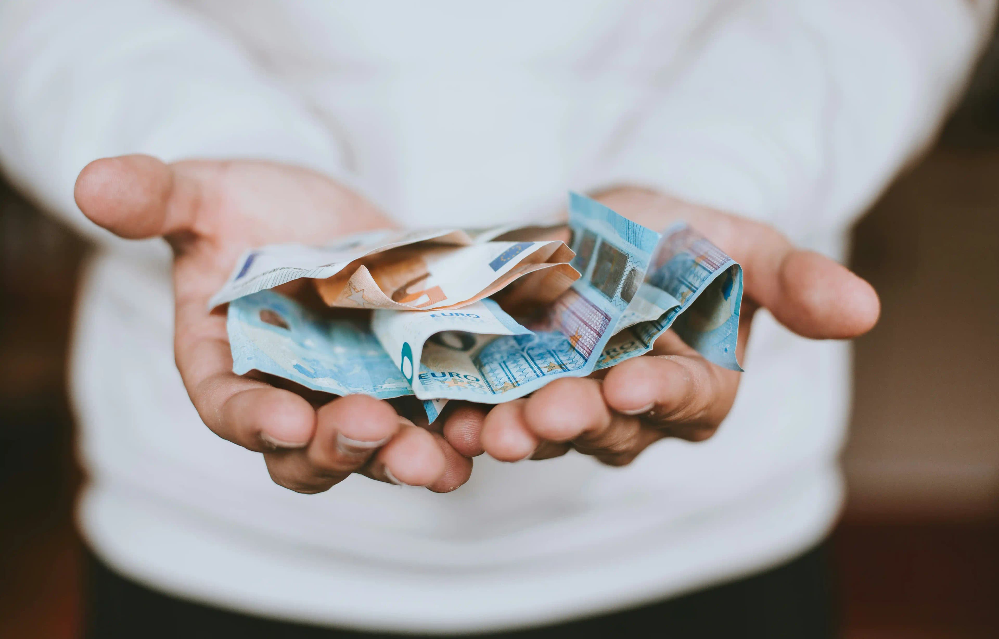 Hands holding money and coins